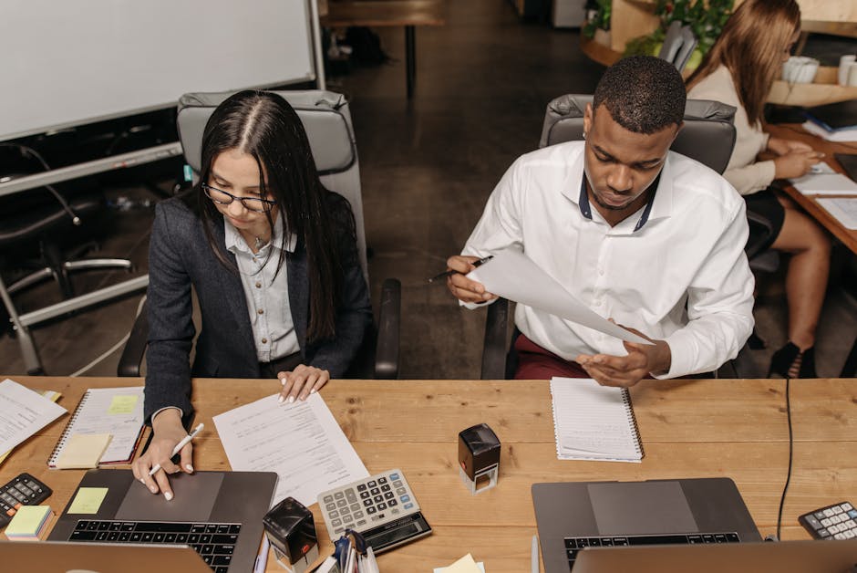 A team gathered around a desk reviewing documents together.